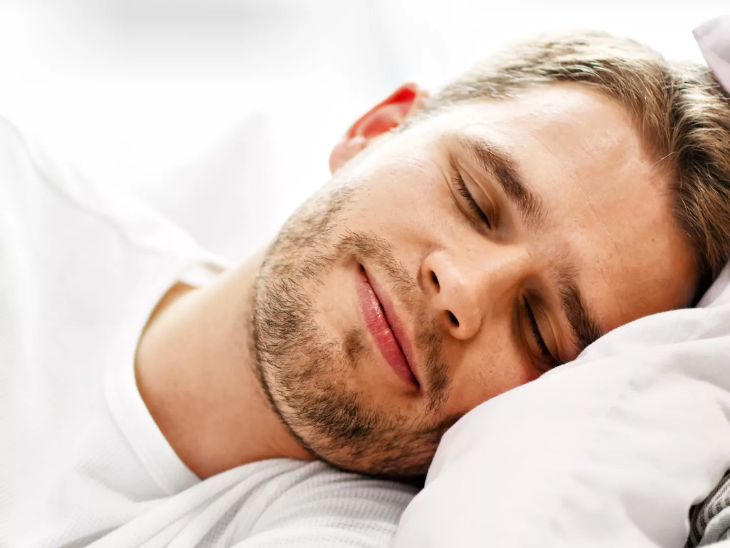 A man sleeping well with a smile.